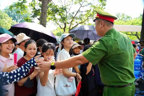 Sau nhiều giờ làm nhiệm vụ ngoài trời, lưng áo của người cán bộ Công an đã ướt đẫm mồ hôi, nhưng anh vẫn liên tục di chuyển, hướng dẫn và hỗ trợ người dân.