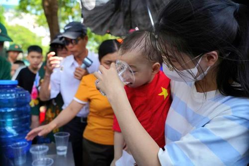 Một chai nước mát được trao đi giữa cái nắng oi bức có thể là điều rất nhỏ, nhưng với những người đã phải di chuyển một quãng đường dài và xếp hàng chờ vào Lăng, đó lại là sự động viên thiết thực.