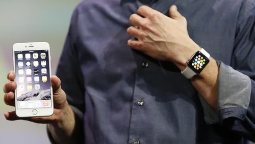 Tim Cook cùng dòng sản phẩm AirPods và Apple Watch. Ảnh: Shutterstock/Reuters.