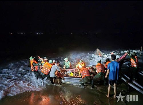 Cán bộ, chiến sĩ Đồn Biên phòng Hải An (Ban chỉ huy BĐBP tỉnh Quảng Trị) xuyên đêm hỗ trợ ngư dân đưa 4 thuyền đánh cá và ngư lưới cụ về nơi an toàn. Ảnh: HOÀI NAM