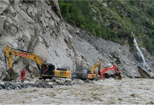 Các máy xúc hạng nặng đang dọn đường dẫn tới cửa khẩu Gyirong tại khu vực bị ảnh hưởng bởi sạt lở đất sau thảm họa lũ quét và sạt lở tại khu vực biên giới Nepal-Trung Quốc. (Nguồn: China News Service)