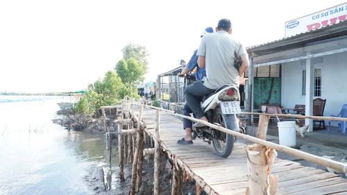 Đường bị sạt lở, người dân đóng góp tiền làm cầu tạm.