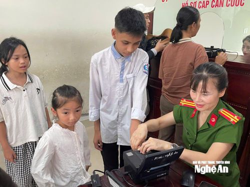 Cán bộ tại Bộ phận một cửa Công an tỉnh lăn tay để làm căn cước cho các em nhỏ. Ảnh tư liệu: P.V