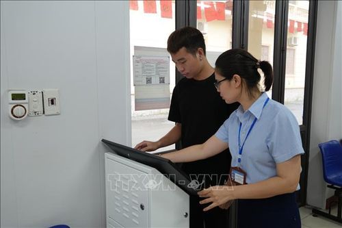 Cán bộ, viên chức Trung tâm phục vụ hành chính công xã Yên Mỹ hướng dẫn người dân nộp hồ sơ qua Cổng Dịch vụ công Quốc gia. Ảnh: Mạnh Khánh/TTXVN