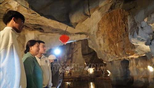 Du khách thích thú với thạch nhũ trong hang núi Mo So.