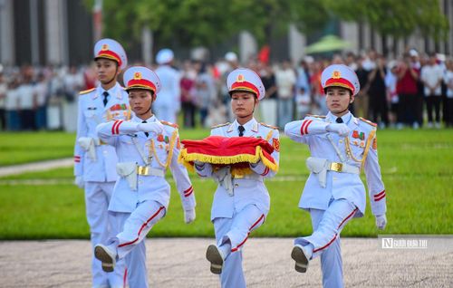 Ba chiến sỹ mang khay đựng quốc kỳ tách khỏi đội hình tiến về cột cờ, chuẩn bị các nghi thức trang trọng.