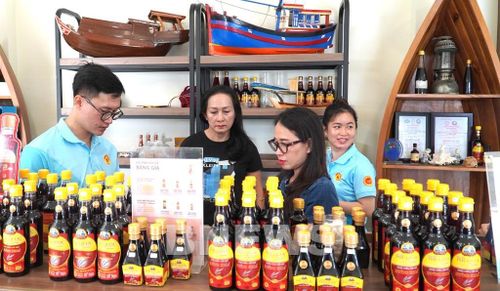 Anh Nguyễn Huỳnh Anh Khoa, Giám đốc cty TNHH kinh doanh nước mắm truyền thống Phú Quốc Huỳnh Khoa tư vấn khách hàng. Ảnh: Văn Sĩ-TTXVN