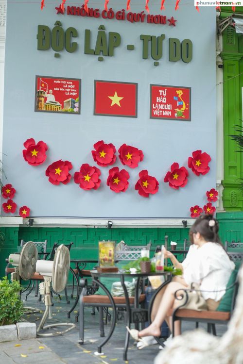 Quán cà phê trang trí chong chóng, hoa giấy đỏ gắn sao vàng cùng những hình ảnh, khẩu hiệu về đất nước, tạo không gian rực rỡ cho du khách check-in, chụp ảnh nhân dịp kỷ niệm 81 năm Cách mạng Tháng Tám và Quốc khánh 2/9.