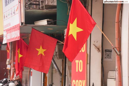 Người dân treo cờ Tổ quốc trước cửa nhà góp phần đưa không khí ngày hội lan tỏa tới từng khu dân cư.