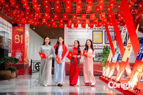 Nhóm bạn trẻ trong trang phục áo dài truyền thống, cầm cờ Tổ quốc chụp hình ở núi Bà Đen.