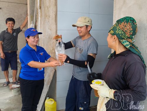 Chị Chang Thị Dung (bên trái) động viên công nhân thi công dự án Trường PTNT liên cấp Tiểu học và THCS Sín Thầu.