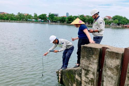Cơ quan chức năng lấy mẫu nước để xác định nguyên nhân cá chết. Ảnh: Đình Việt