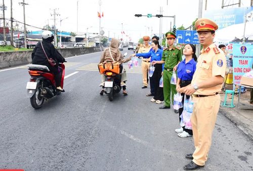Lực lượng Công an, đoàn viên thanh niên phát nước suối và khăn lạnh tặng người dân.