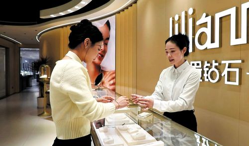  Khách hàng đang xem xét mua trang sức kim cương nhân tạo tại cửa hàng ở Chá Thành, tỉnh Hà Nam, Trung Quốc. (Ảnh: China Daily)