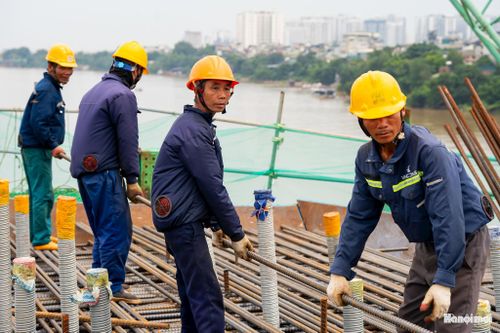 Đằng sau những khối thép từng bước vươn lên giữa sông Hồng là sự nỗ lực thầm lặng của những người công nhân.