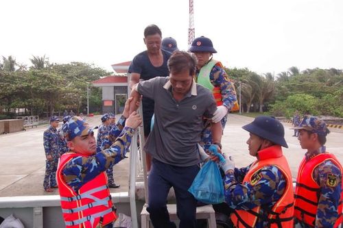 Từng ngư dân được hỗ trợ đưa lên tận tàu để bắt đầu hành trình về đất liền. Ảnh: Thành Vũ.