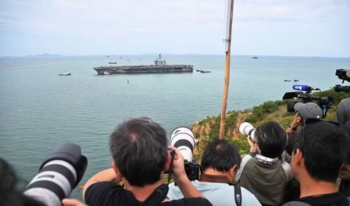 Các phóng viên đang chờ đợi chụp ảnh tàu sân bay USS Abraham Lincoln ngoài khơi cảng Laem Chabang, gần thành phố Pattaya của Thái Lan, sau hơn 270 ngày lênh đênh trên biển. Ảnh: AFP/Getty Images