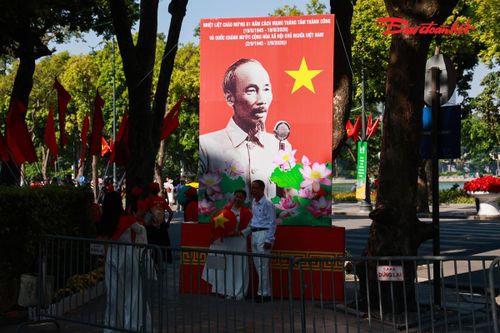 Khu vực quanh Hồ Gươm và những tuyến phố trung tâm trở thành điểm đến thu hút đông đảo người dân. Nhiều người lựa chọn trang phục áo dài, quàng lá cờ Tổ quốc để ghi lại những khoảnh khắc đáng nhớ trong ngày lễ trọng đại của đất nước. Ảnh: Quang Vinh.