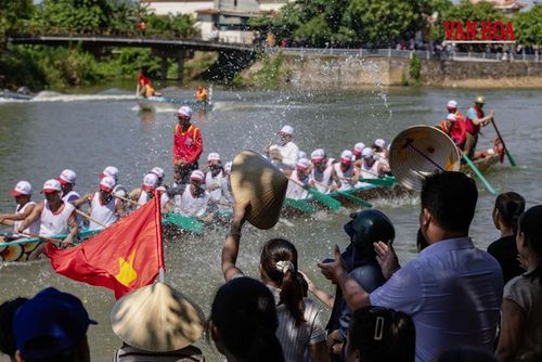 Thuyền vừa lao qua, tiếng reo hò, những chiếc nón vẫy cao và cờ Tổ quốc hòa vào những đợt nước tung trắng mặt sông