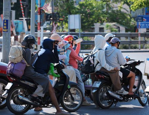 Người dân với hành lý, đồ đạc và những món quà quê được chằng buộc gọn gàng, nối tiếp nhau từ quốc lộ 1A hướng về đường Giải Phóng vào nội đô. Ảnh: Hoàng Hiếu - TTXVN
