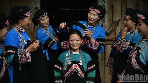 Hướng dẫn người trẻ học cách vấn khăn. (Ảnh: VŨ LINH)