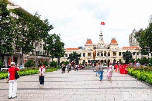 Người dân, du khách tham quan, chụp ảnh lưu niệm tại khu vực tượng đài Chủ tịch Hồ Chí Minh.