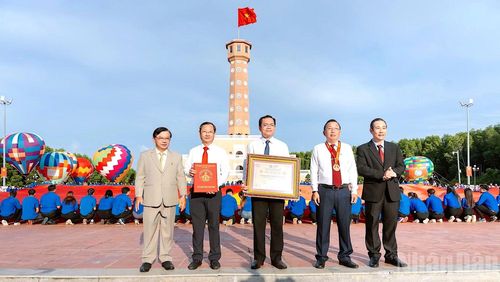Đại diện lãnh đạo tỉnh Cà Mau đón nhận Bằng Kỷ lục “Lá cờ Tổ quốc bằng vải lớn nhất Việt Nam” do đại diện Trung ương Hội Kỷ lục gia Việt Nam trao tặng. (Ảnh: HỮU TÙNG)