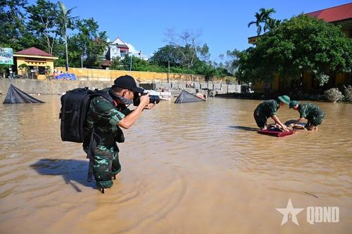 Phóng viên ảnh Trịnh Phú Sơn, Báo Quân đội nhân dân tác nghiệp tại khu vực ngập lụt tỉnh Bắc Ninh, tháng 10-2025. Ảnh: qdnd.vn