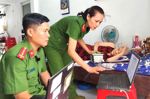 Cán bộ Công an xã Hóc Môn tận tình hướng dẫn, thực hiện lăn tay làm thủ tục cấp căn cước cho người cao tuổi tại nhà riêng. Ảnh: NGUYỄN TÂN 