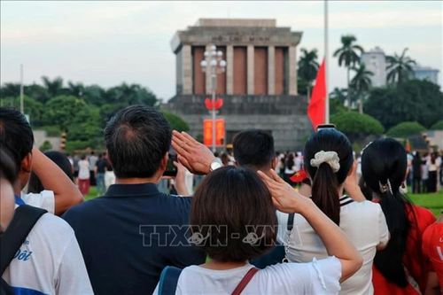 Nhân dân thực hiện nghi thức chào cờ, hướng về Lăng Chủ tịch Hồ Chí Minh trong thời khắc Quốc ca vang lên hùng tráng trên Quảng trường Ba Đình. (Nguồn: TTXVN)