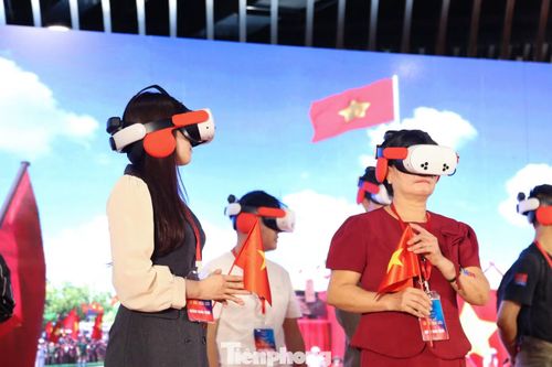 Sau 2 tiếng đồng hồ xếp hàng, chị Đặng Thị Thùy Trang (giảng viên Đại học Duy Tân) cùng mẹ mới đến lượt tham gia trải nghiệm. Đeo kính thực tế ảo, chị Trang chăm chú theo dõi, hòa vào sự kiện lịch sử thiêng liêng.