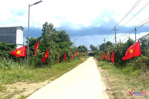 Cờ đỏ tung bay trên tuyến đường làng vào thôn 9. Ảnh: Hải Dương