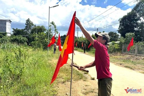 Anh Tuấn tham gia cắm cờ cùng cán bộ thôn. Ảnh: Hải Dương