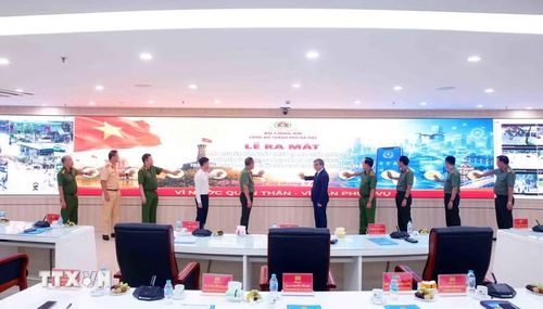 Các đại biểu thực hiện thi thức Lễ ra mắt, giới thiệu dây chuyền sản xuất thiết bị báo cháy không dây; thí điểm ứng dụng Cảnh sát Hà Nội thông minh (Hanoi Smart Police) và triển khai giai đoạn 2 giải pháp UAV giám sát an ninh trật tự. (Ảnh: Phạm Kiên/TTXVN)