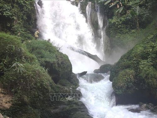 Nước tại thác Khâu Làn (xã Quản Bạ, Tuyên Quang) chảy xiết, địa hình nhiều đá lớn, gây khó khăn cho việc tiếp cận và tìm kiếm du khách mất tích. Ảnh: TTXVN phát