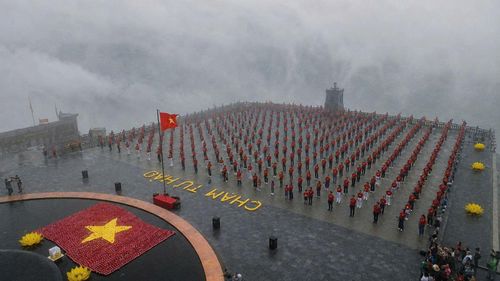 Giữa không gian mây mờ bao phủ, người dân thành kính hướng về lá cờ đỏ sao vàng tung bay trên đỉnh núi Bà Đen.