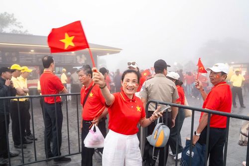 Người dân vui vẻ mang theo cờ và mặc áo cờ đỏ sao vàng chuẩn bị cho lễ chào cờ thiêng liêng trên đỉnh núi Bà Đen.