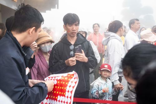 Người dân được tặng miếng dán hình cờ đỏ sao vàng khi lên núi Bà Đen.