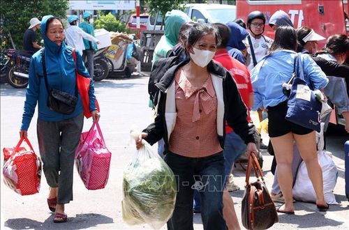 Người dân vội vã trở về nhà với đồ đạc lỉnh kỉnh trên tay tại bến xe Giáp Bát.