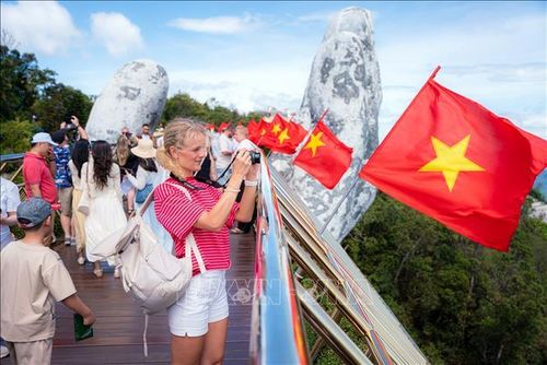 Du khách quốc tế thích thú chụp ảnh tại Cầu Vàng của Khu du lịch Sun World Bà Nà Hills trong dịp lễ. Ảnh: TTXVN phát