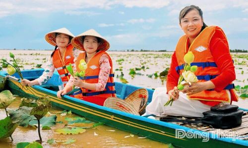 Du khách chụp ảnh trên đồng sen mùa nước nổi tại xã Thường Phước.