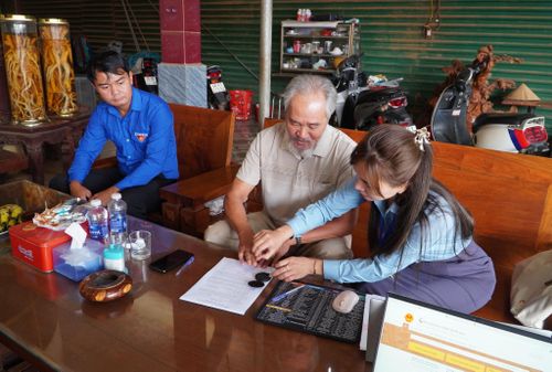 Cán bộ, công chức xã Quảng Trực tận tình hướng dẫn người lớn tuổi sử dụng dịch vụ công trực tuyến.