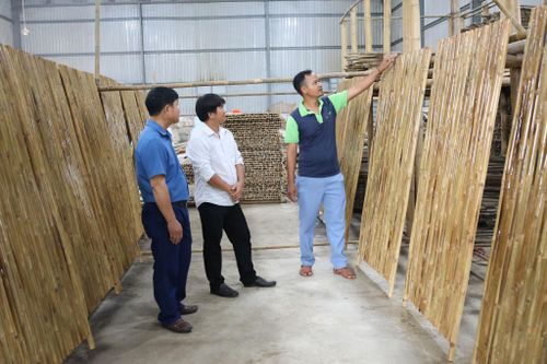 Anh K’Mưn (bên phải) giới thiệu các công đoạn tạo ra sản phẩm tại Hợp tác xã Sơ chế tre tầm vông Tố Lan.