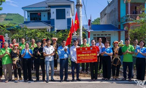 Đại diện Ủy ban MTTQ xã Trại Cau trao tặng công trình đường cờ cho nhân dân thôn 4.