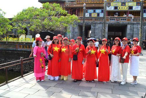 Một nhóm du khách mặc áo cờ đỏ sao vàng tham quan Đại nội Huế.