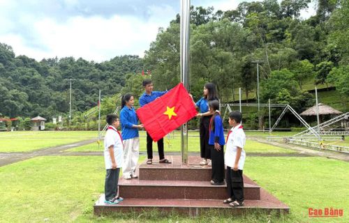 Bí thư Chi đoàn xóm Pác Bó Dương Văn Thượng hướng dẫn đoàn viên, thanh thiếu nhi treo cờ Tổ quốc.
