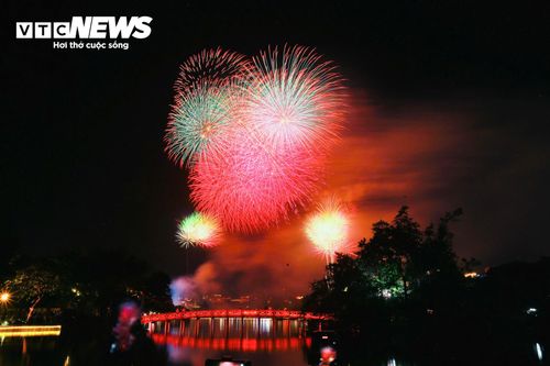Đúng 21h, tiếng đếm ngược vang lên giữa biển người. Những loạt pháo hoa đầu tiên vút lên rồi bung nở rực rỡ trên nền trời Hà Nội.
