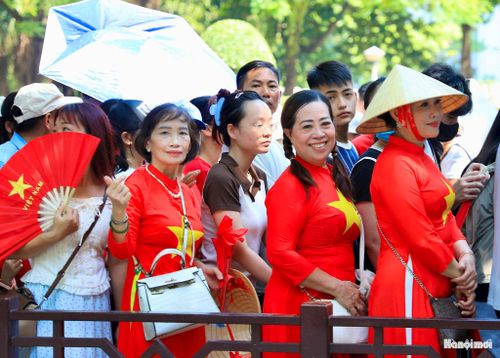 Nhiều người diện đồng phục áo đỏ với sao vàng trước ngực khi vào Lăng.