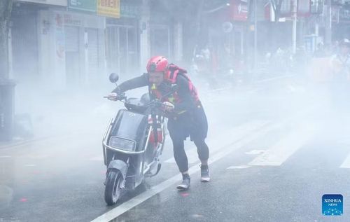 Nhân viên cứu hộ di chuyển chiếc xe đạp điện bị bốc cháy sau khi đi qua vùng nước lũ ở thành phố Phúc An, tỉnh Phúc Kiến ngày 2-9-2026