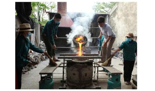 Nghệ nhân rót đồng nóng chảy vào trong khuôn đúc trống và trống đồng sau khi dỡ khuôn